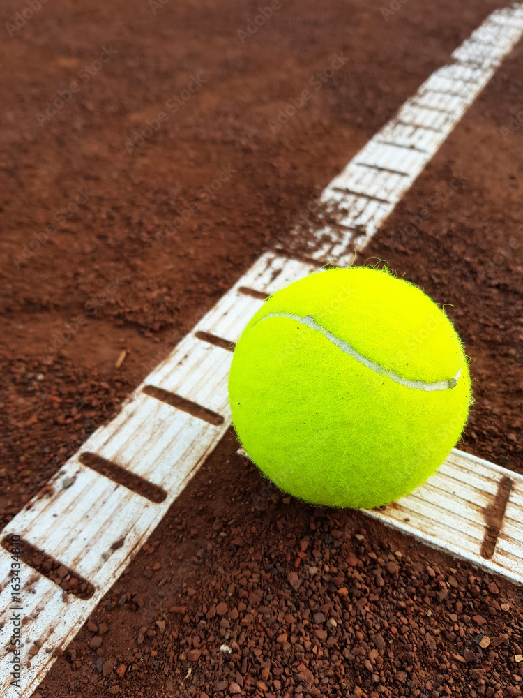 Racket and tennis ball on tennis court