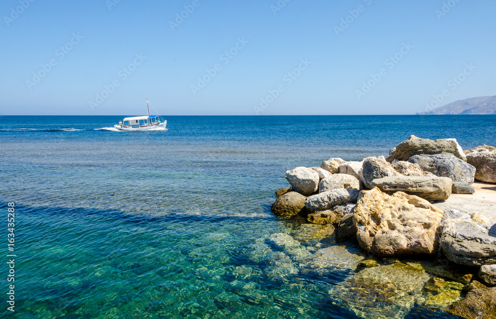 Smal fishing boat floating on turquoise calm waters of Skiros island, Greece