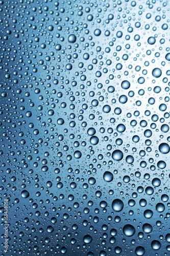 Water drops on surface, abstract blue background