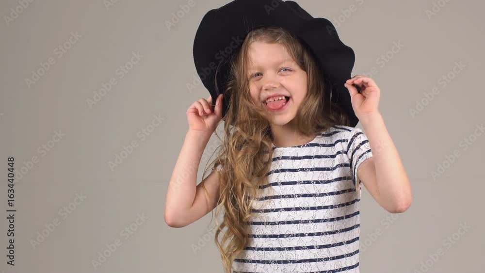 Portrait of a little girl in a hat. Child posing for the camera. Portrait of a little girl in a hat. Child posing for the camera.