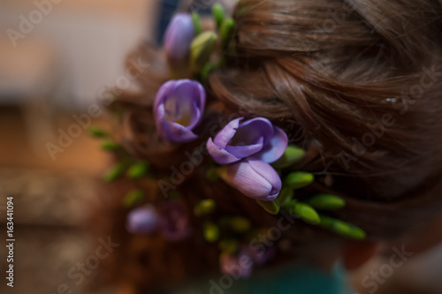 Flowers of lilac freesia in the bride's hair