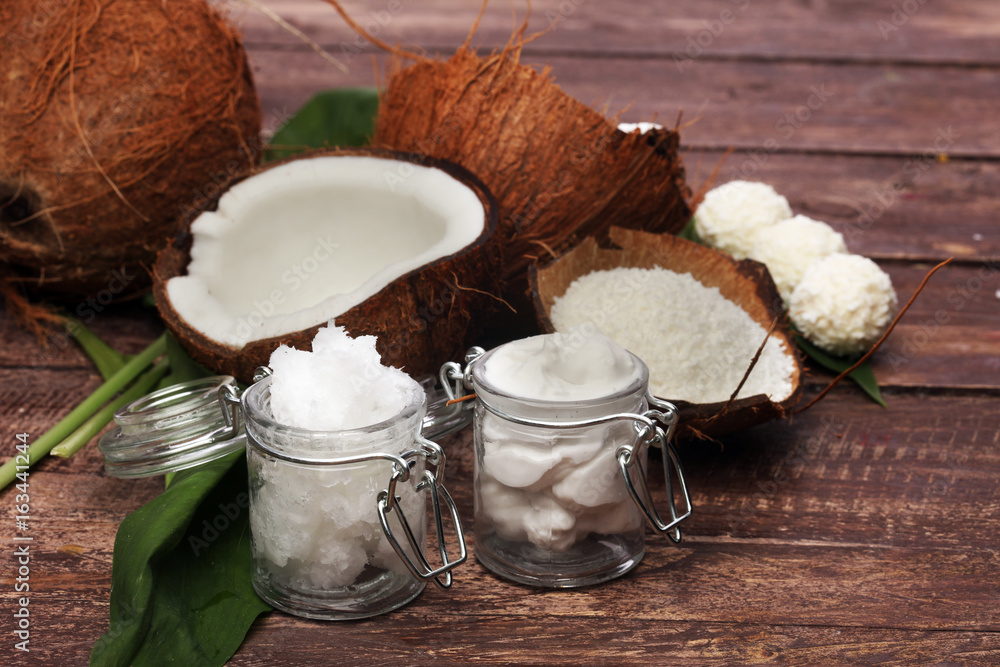 Coconut with leaves and coconut oil in jar Coconut with leaves and coconut oil in jar