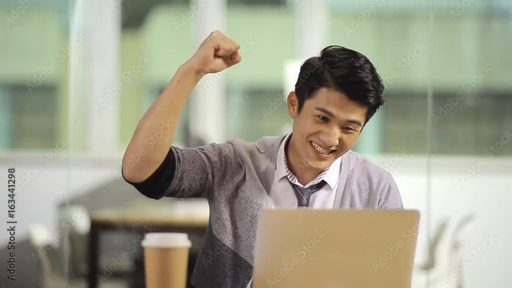 young asian businessman celebrating achievement and success in office young asian businessman celebrating achievement and success in office