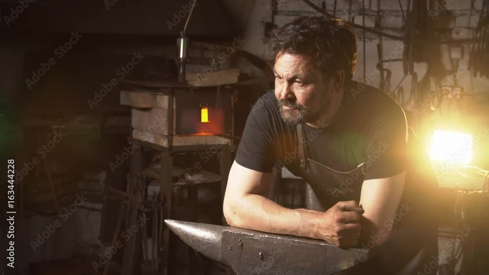 Portrait of a man of a blacksmith in the working atmosphere. Portrait of a man of a blacksmith in the working atmosphere.