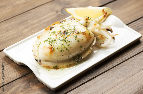 Bild auf Leinwand Close-up of cuttlefish with garlic and parsley and lemon on wooden table