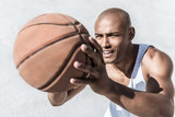 selective focus of african american basketball player holding ball in hands