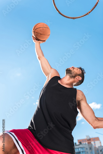 low angle view of basketball player throwing ball into basket