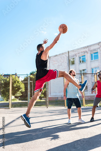 basketball player catching ball while playing basketball with team