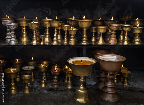 Buddhist ritual oil lamp shaped a cup with fire as donation. photo