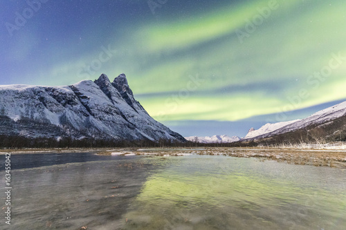 The snowy peak of Otertinden and the Northern Lights (aurora borealis) in the polar night, Oteren, Lyngen Alps, Troms photo