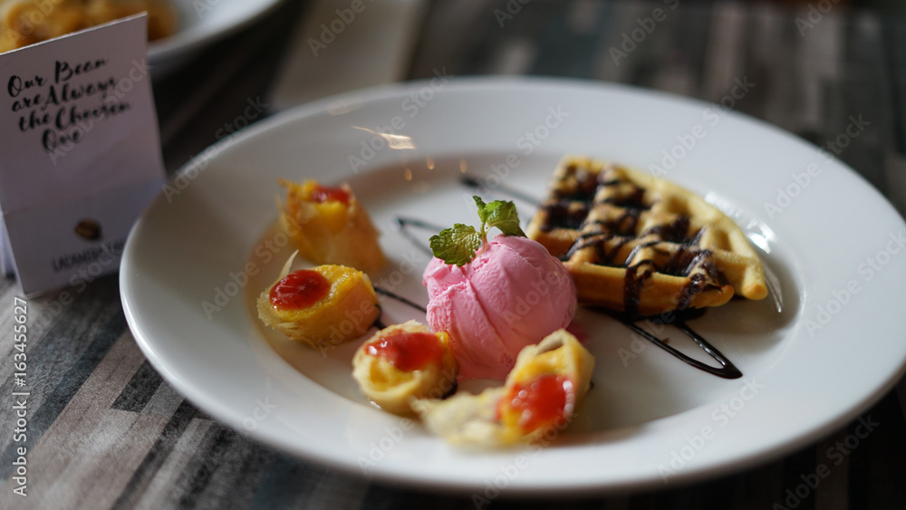 a sweet and tasty wafles with chocolate and strawberry ice cream. a sweet and tasty wafles with chocolate and strawberry ice cream.