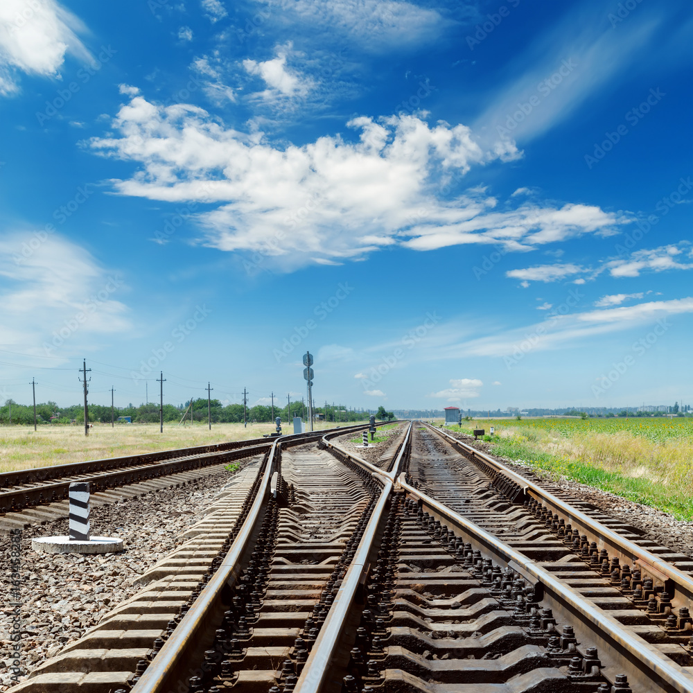 crossing of railroads and blue sky with clouds