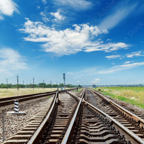 crossing of railroads and blue sky with clouds