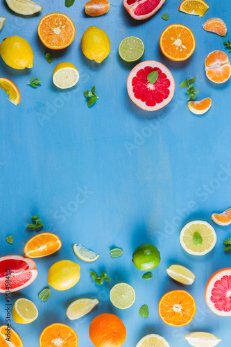 Fototapeta Naklejka Na Ścianę i Meble -  citrus food flat lay borders pattern on blue background - assorted citrus fruits with mint leaves