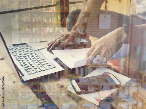 Double exposure of Businessmen use computers and blur library books