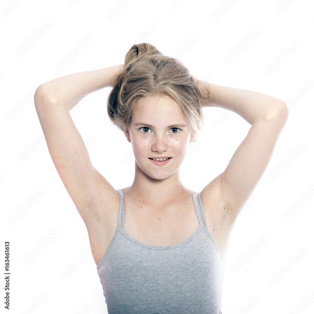  young teen girl holds blond hair up against white background