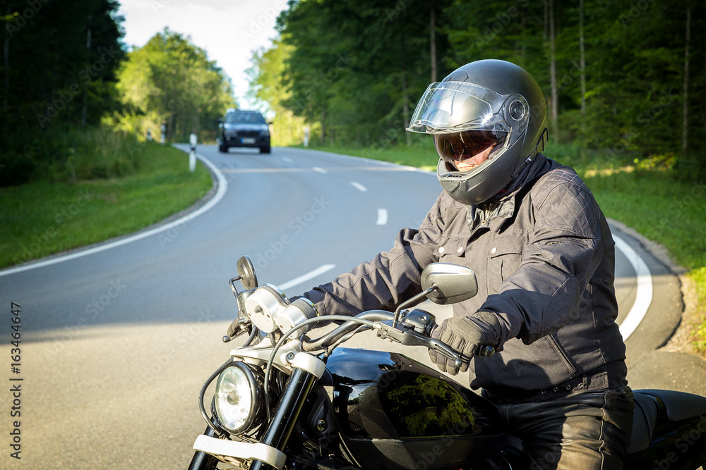 The biker sits on a motorcycle The biker sits on a motorcycle