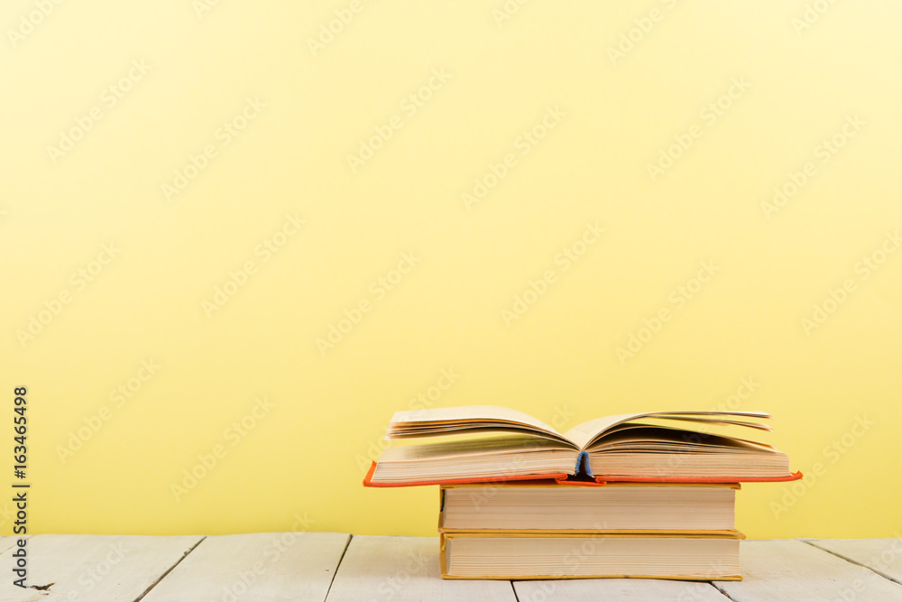 education and wisdom concept - open book on wooden table, color background education and wisdom concept - open book on wooden table, color background