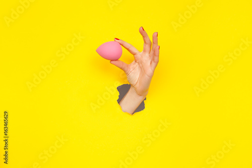 Fotografie Hand holding cosmetic sponge