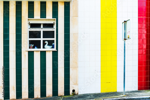 A window in a wooden house with colorful stripes in Costa Nova. Aveiro. Portugal.