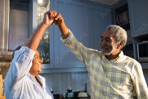 Affectionate couple dancing in kitchen photo