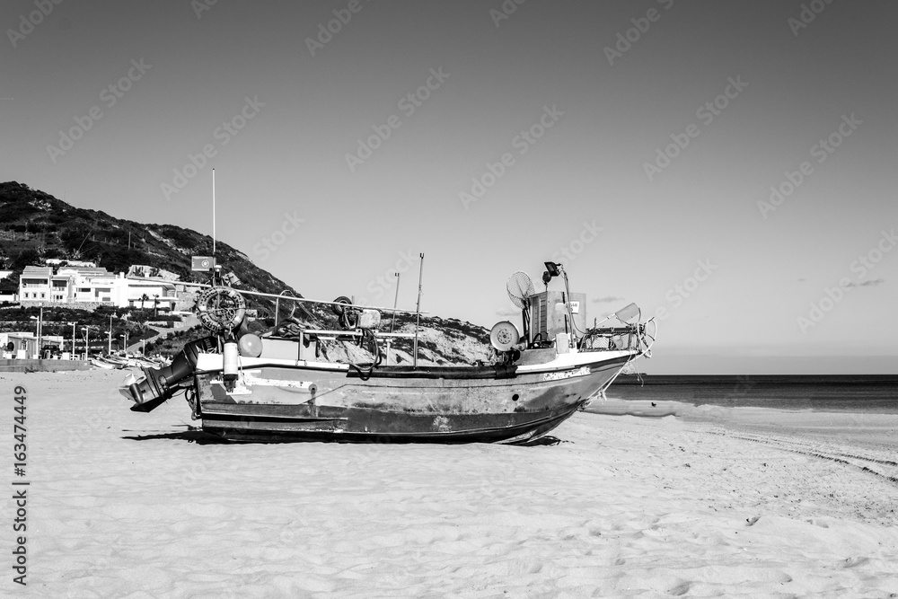 Fototapeta premium Stranded boat in the beach of Salema (Algarve, Portugal)
