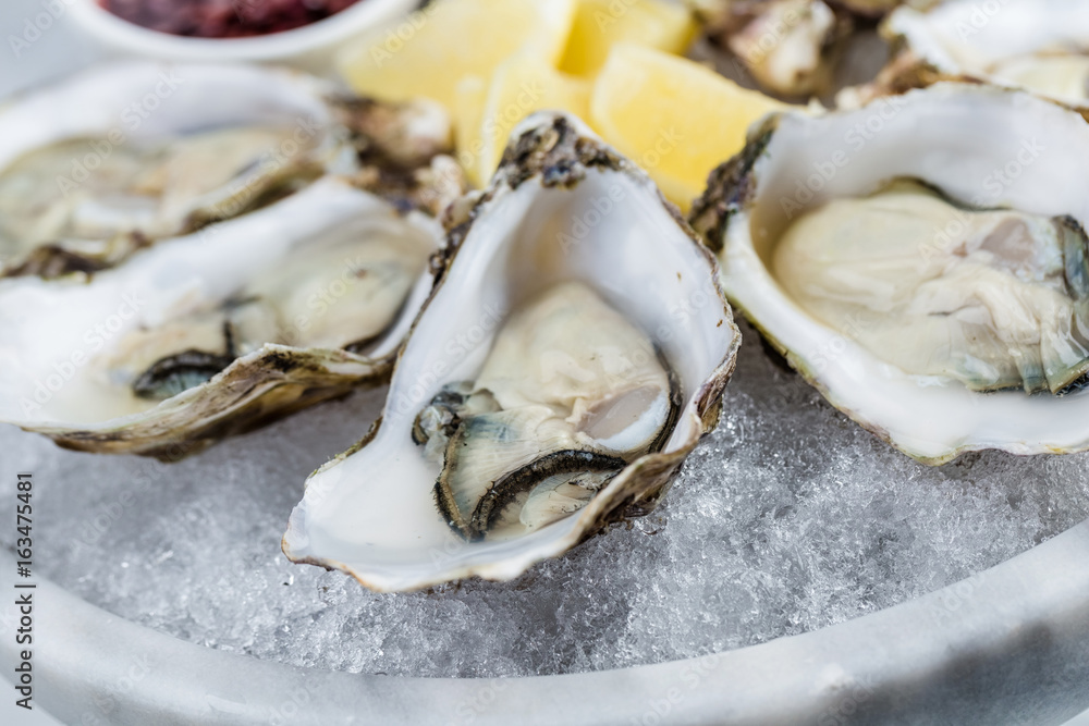 Fresh oysters platter with sauce and lemon Fresh oysters platter with sauce and lemon