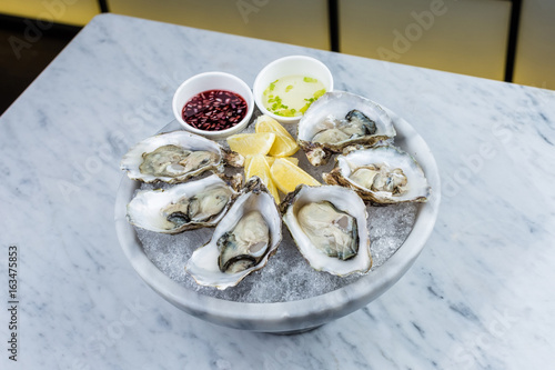Fresh oysters platter with sauce and lemon