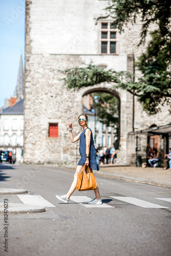 Beautiful woman crossing the street at the old town of Nantes city in France