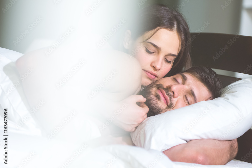 The happy man and woman relax on the bed The happy man and woman relax on the bed
