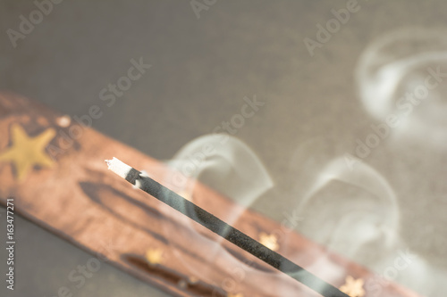 Burning incense sticks with smoke on dark background