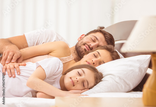 The family sleeping in the comfortable bed. full grip focus