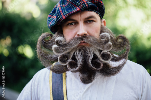 Fotografia Handsome portrait of a brave Scot with a amazing beard and mustache curls in the Hungarian style