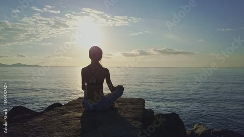Girl Silhouette Sits in Pose under Bright Sun Path photo