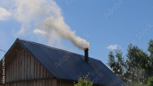 From the pipe goes gray smoke against the blue sky