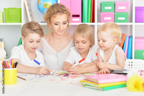Mother drawing with three cute sons