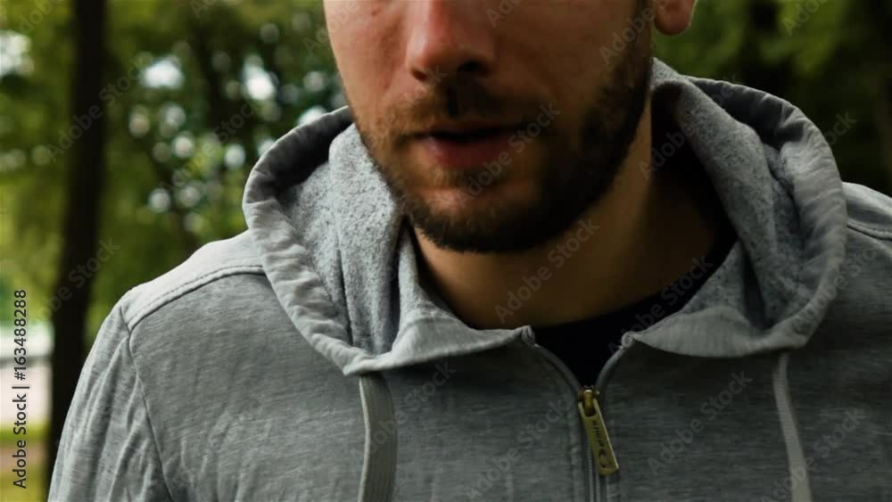 Caucasian Man Runner tired while running in park. Extreme close-up portrait. Green colors. Super slow motion shot. Caucasian Man Runner tired while running in park. Extreme close-up portrait. Green colors. Super slow motion shot.