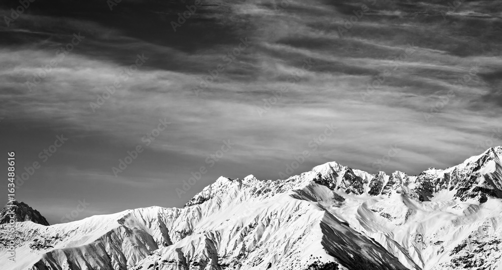 Black and white panoramic view on winter mountains at sun winter day