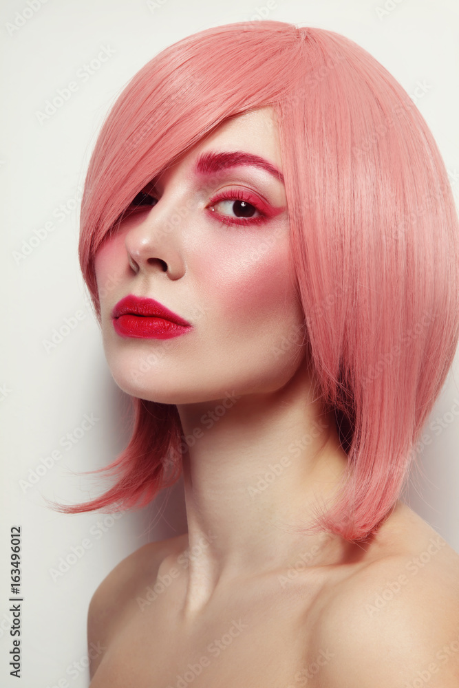 Portrait of young beautiful woman in pink wig