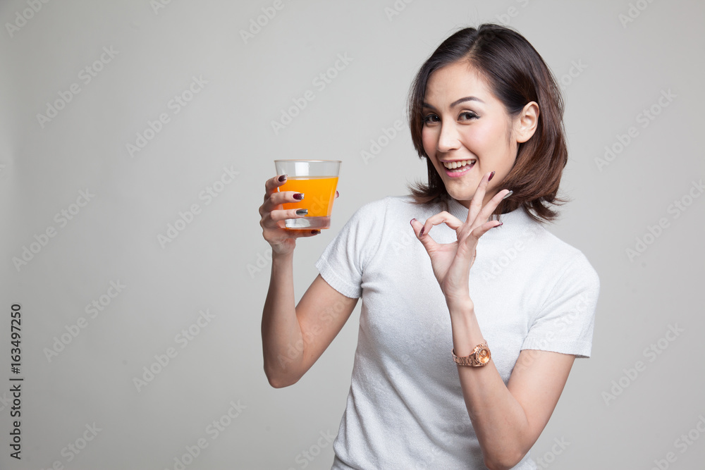 Young Asian woman show OK drink orange juice. Young Asian woman show OK drink orange juice.
