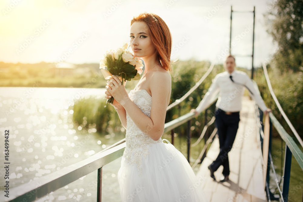 bride and groom are standing on the bridge bride and groom are standing on the bridge