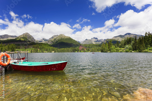 Panorama mountain lake Strbske Pleso in the Tatra mountains. Summers colors and boat for swimming.