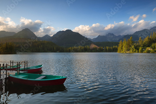 Panorama mountain lake Strbske Pleso in the Tatra mountains. Summer sunset colors and boat for swimming.