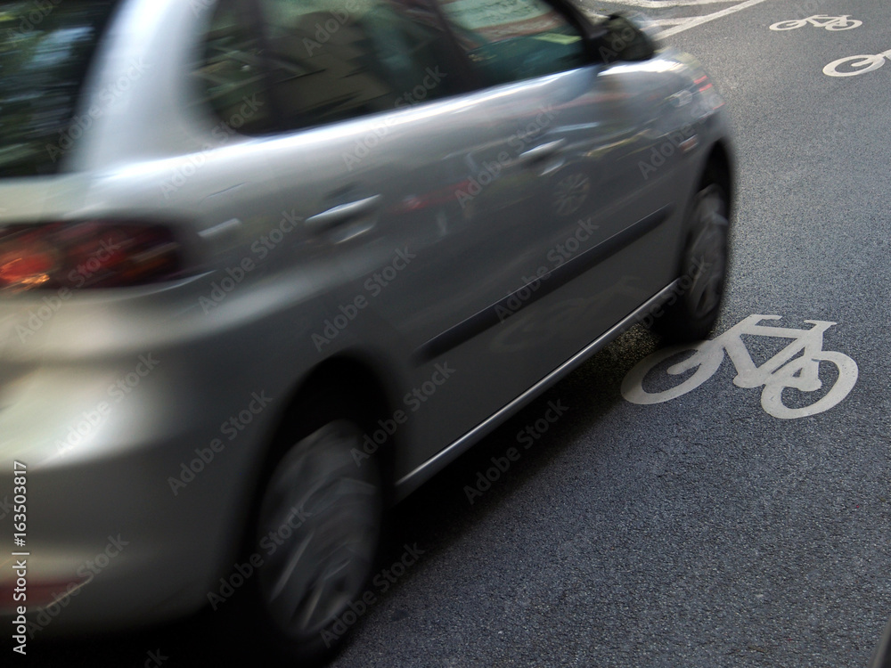 Fototapeta premium Verkehrssicherheit: Auto auf Fahrbahnmarkierung für Radweg