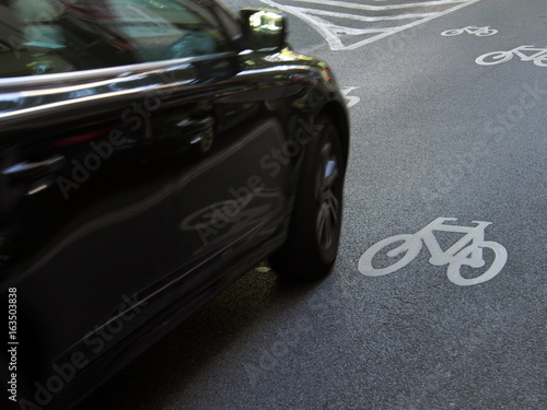 Verkehrssicherheit: Auto auf Fahrbahnmarkierung Radweg photo