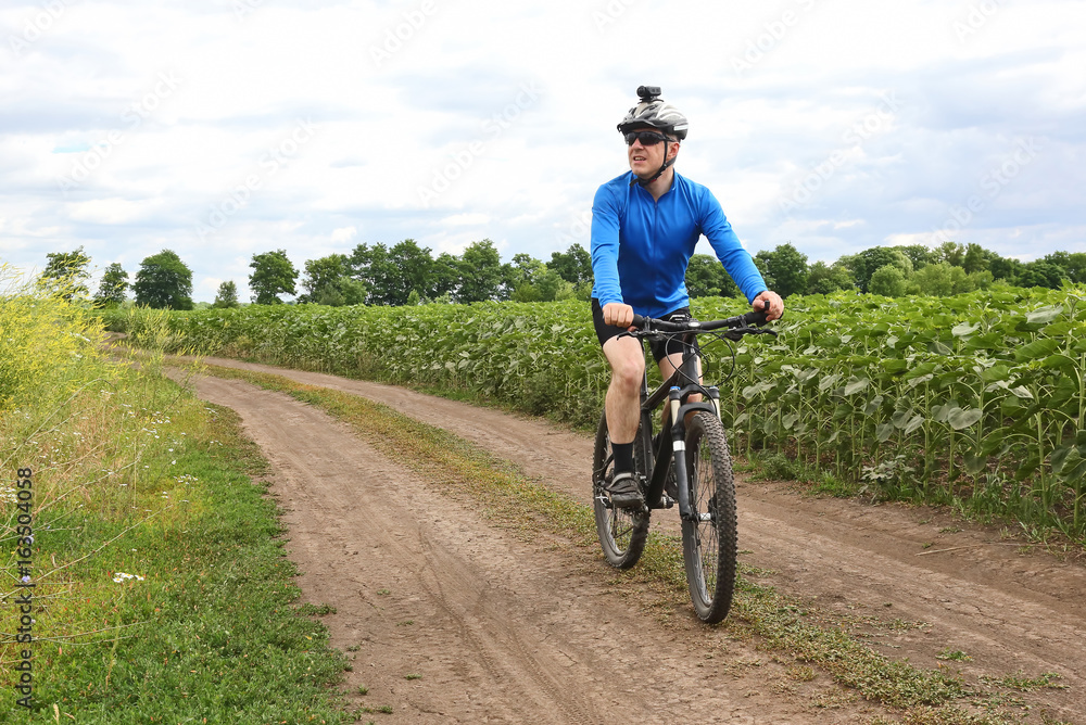 cyclist rides along a field trail cyclist rides along a field trail