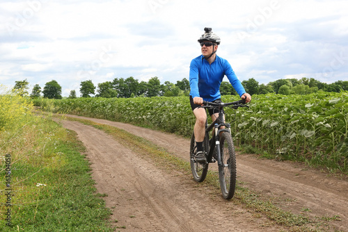 cyclist rides along a field trail © photosaint