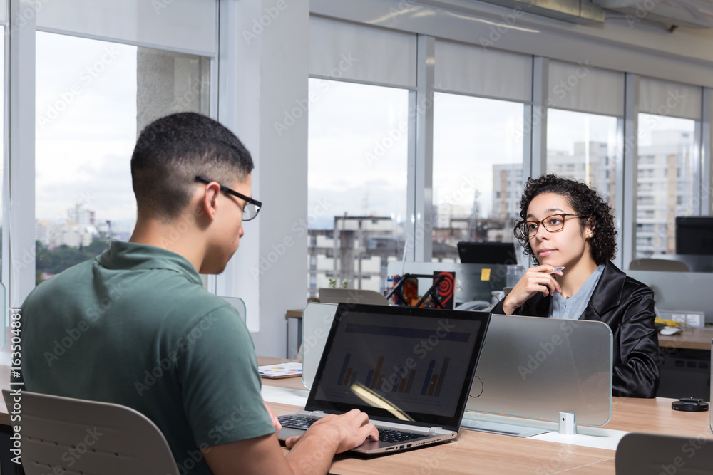 Young woman looks at the coworker at the front. Young woman looks at the coworker at the front.