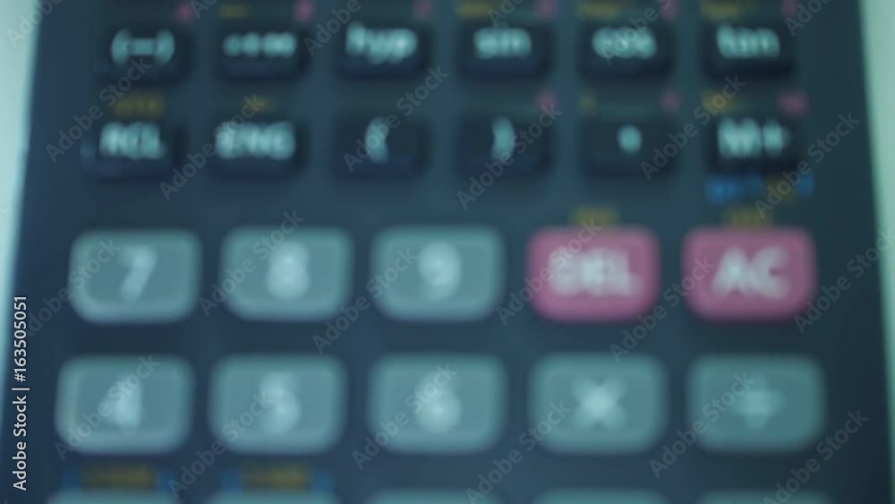 Finger presses the engineering calculator buttons. Closeup shot Finger presses the engineering calculator buttons. Closeup shot