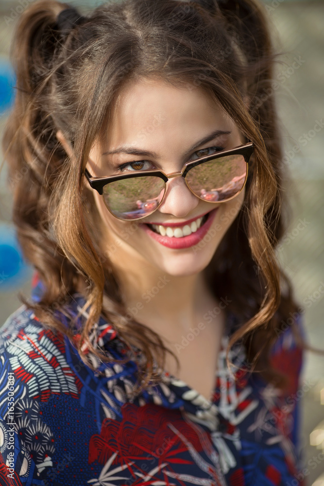 Close-up of a happy young woman wearing sunglasses Close-up of a happy young woman wearing sunglasses